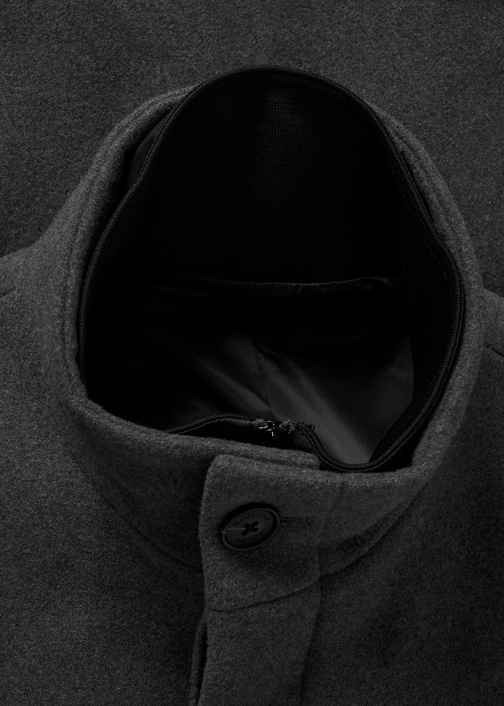 Close-up of a dark gray coat with a hood on a black background