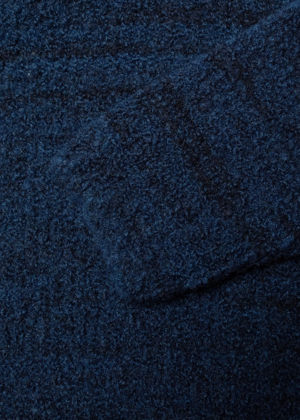 A close-up of dark navy blue textured fabric with a soft, plush or bouclé-like surface.