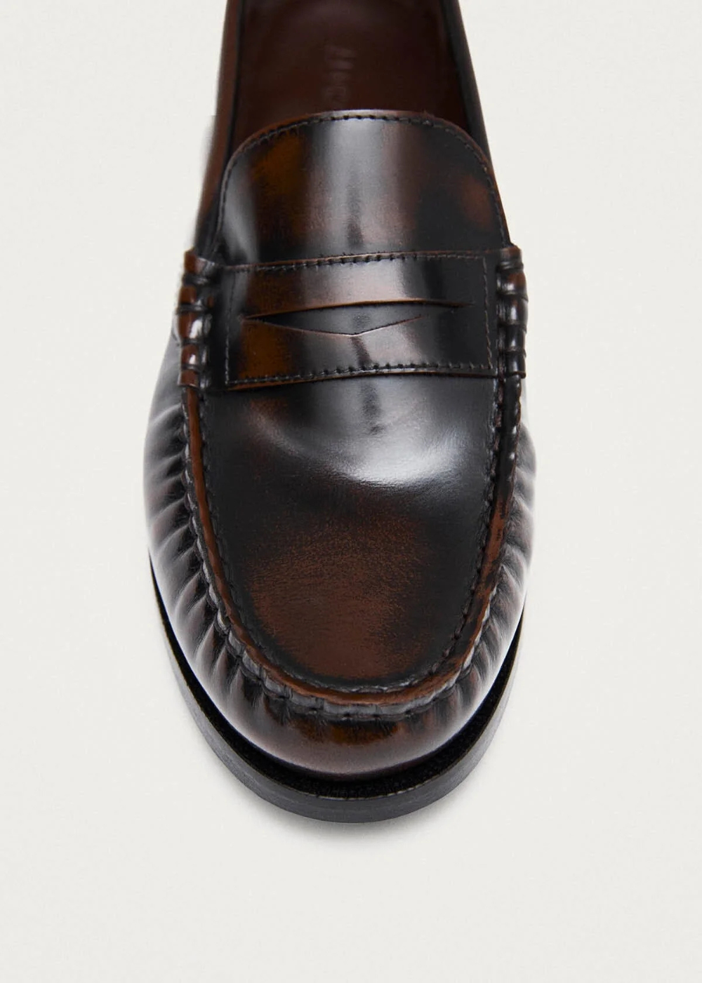 Brown leather loafer shoe on a light gray background