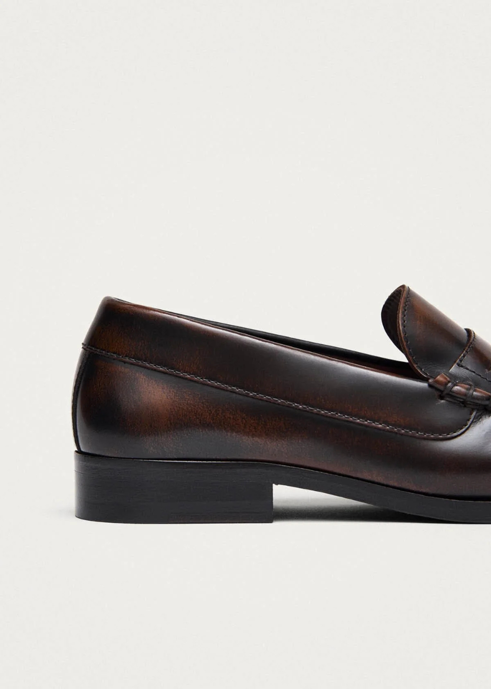 Brown leather loafer shoe on a light gray background