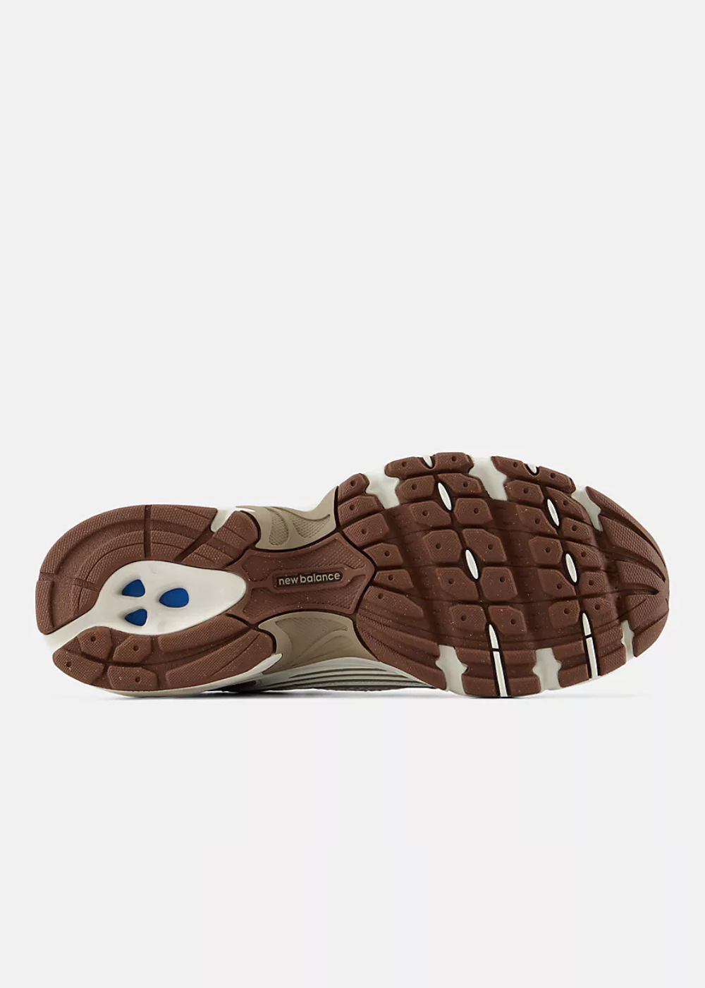 The outsole of a New Balance sneaker, showing a brown and beige tread pattern with a small blue logo on the heel, photographed against a light gray background.