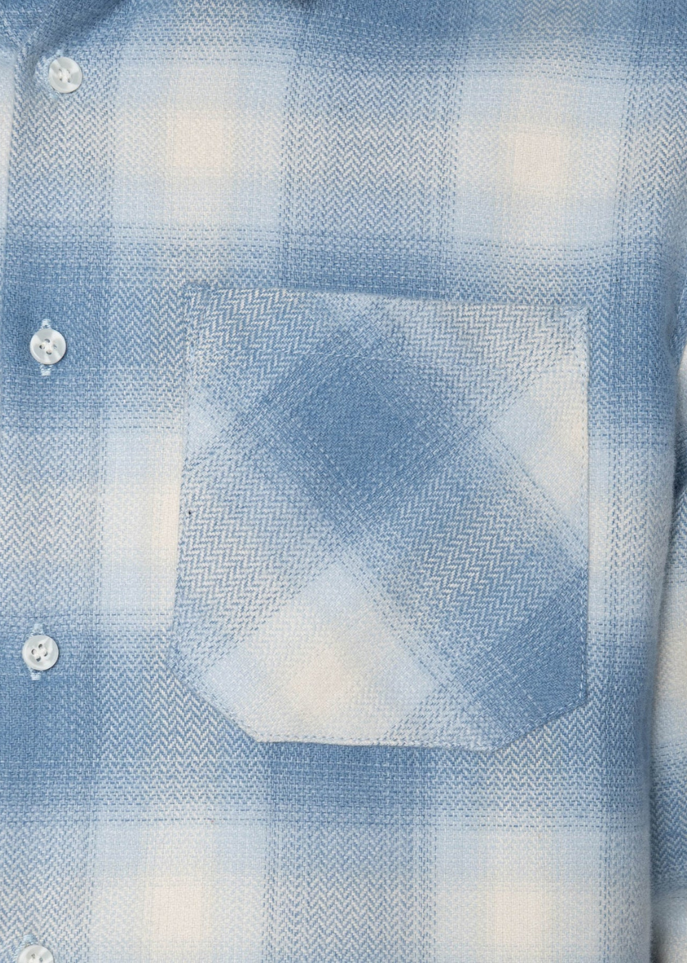 Close-up of a light blue and white plaid button-up shirt with a chest pocket and visible herringbone weave texture.