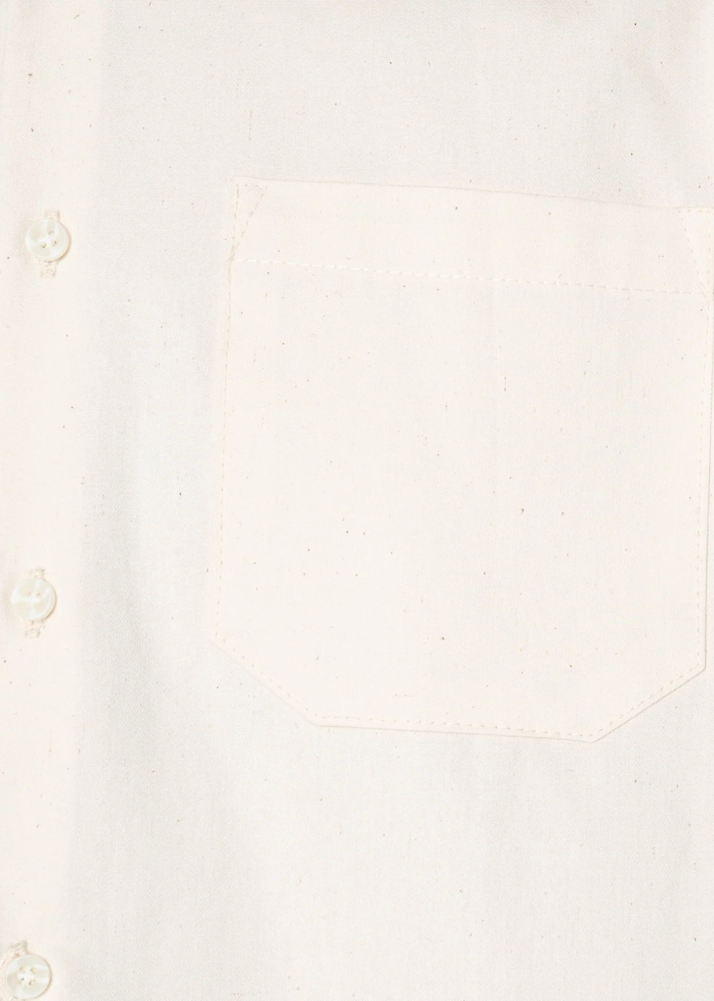 Close-up of a white or off-white shirt fabric with a rectangular chest pocket and partial visible buttons along the left side.