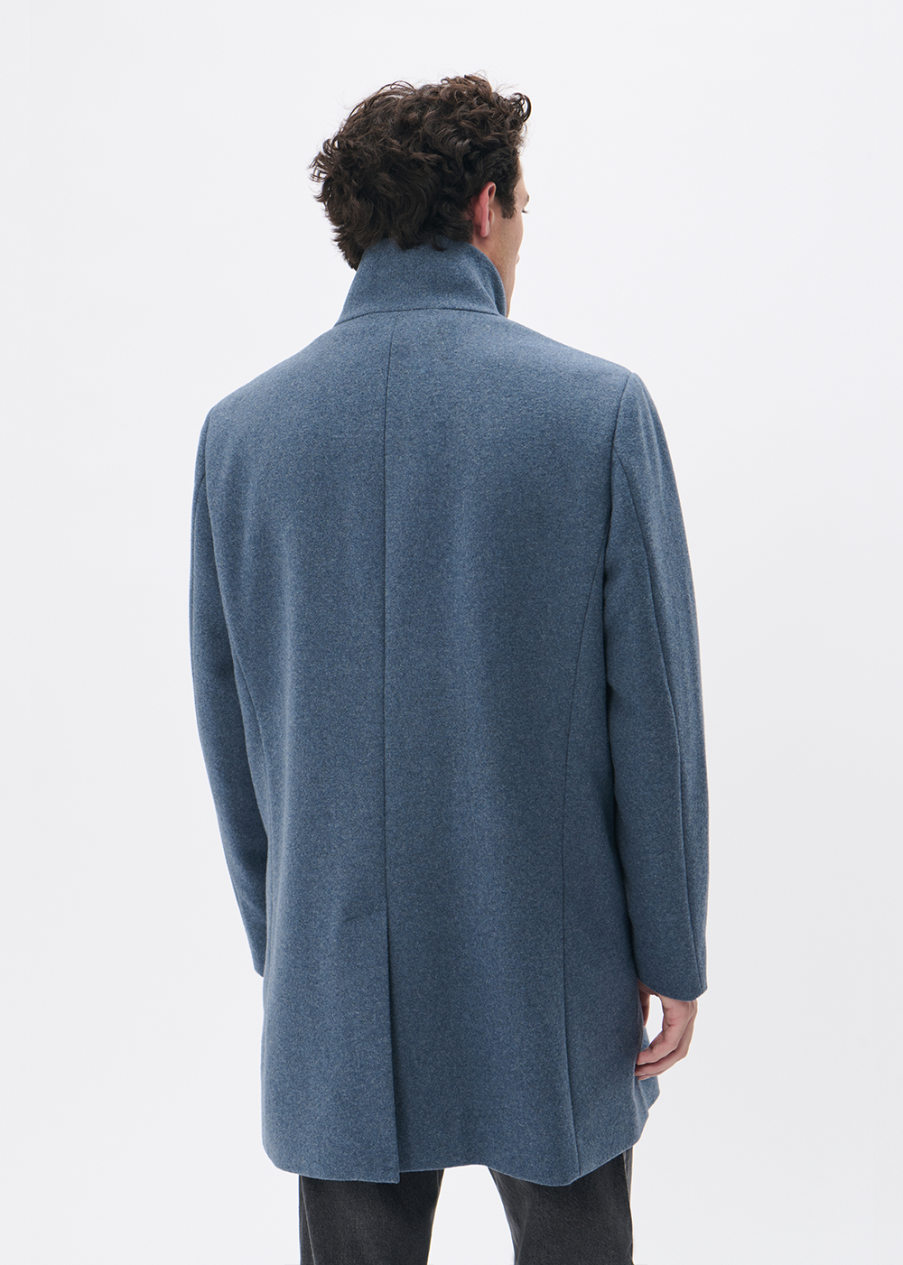 Man wearing a blue coat from behind on a white background