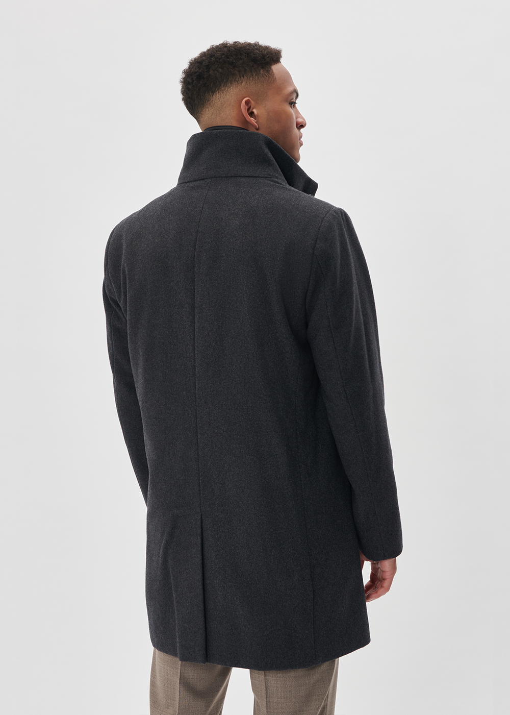 Man wearing a dark gray coat on a white background