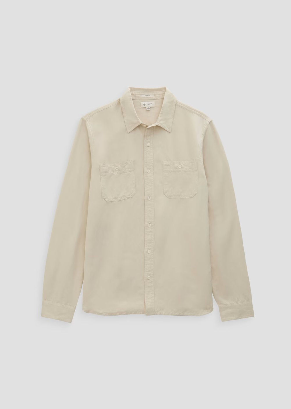 A light beige long-sleeve button-up shirt with two chest pockets, laid flat against a light gray background.