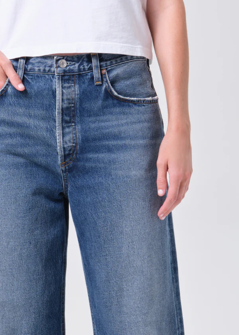 Blue jeans worn by a person on a white background
