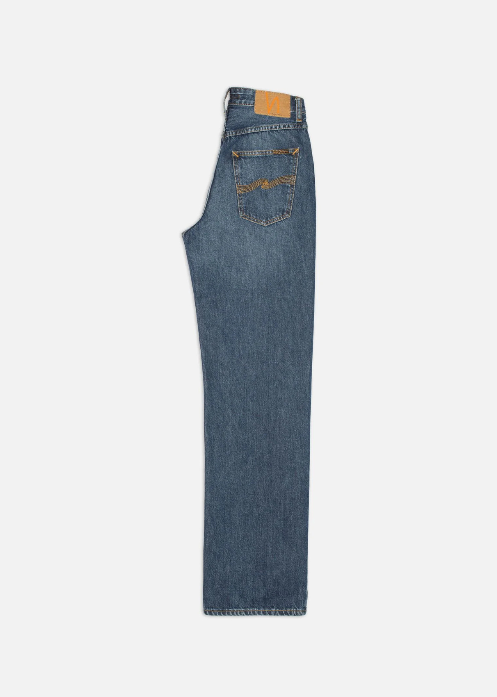 A pair of medium-wash blue denim jeans shown from the back, featuring a tan leather patch on the back waistband and a decorative embroidered patch on the right back pocket, set against a plain white background.