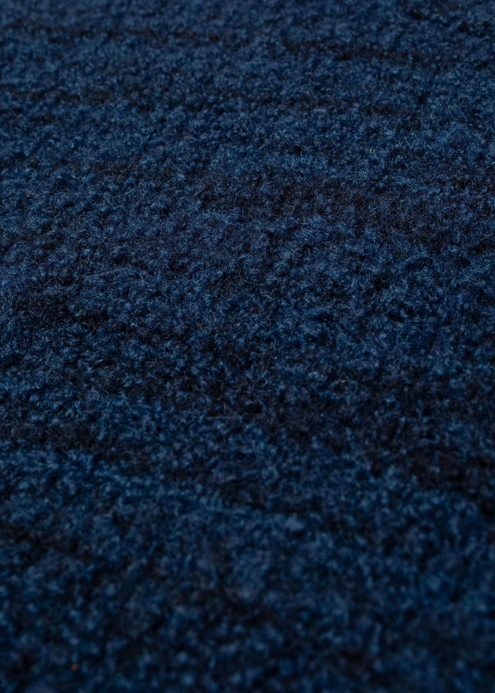 A close-up texture shot of a dark navy blue shaggy or plush fabric surface.