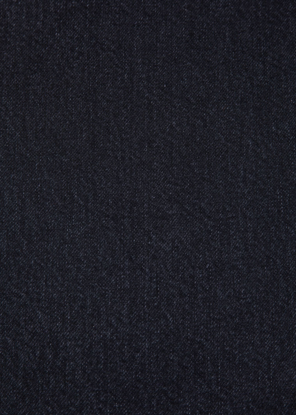 A close-up of vintage black denim fabric texture, showing a fine woven pattern.