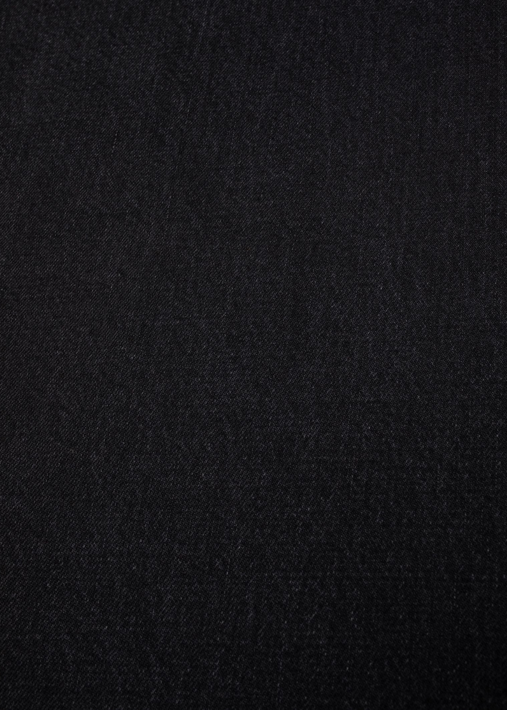 A close-up texture shot of a solid black fabric, showing a fine woven pattern.