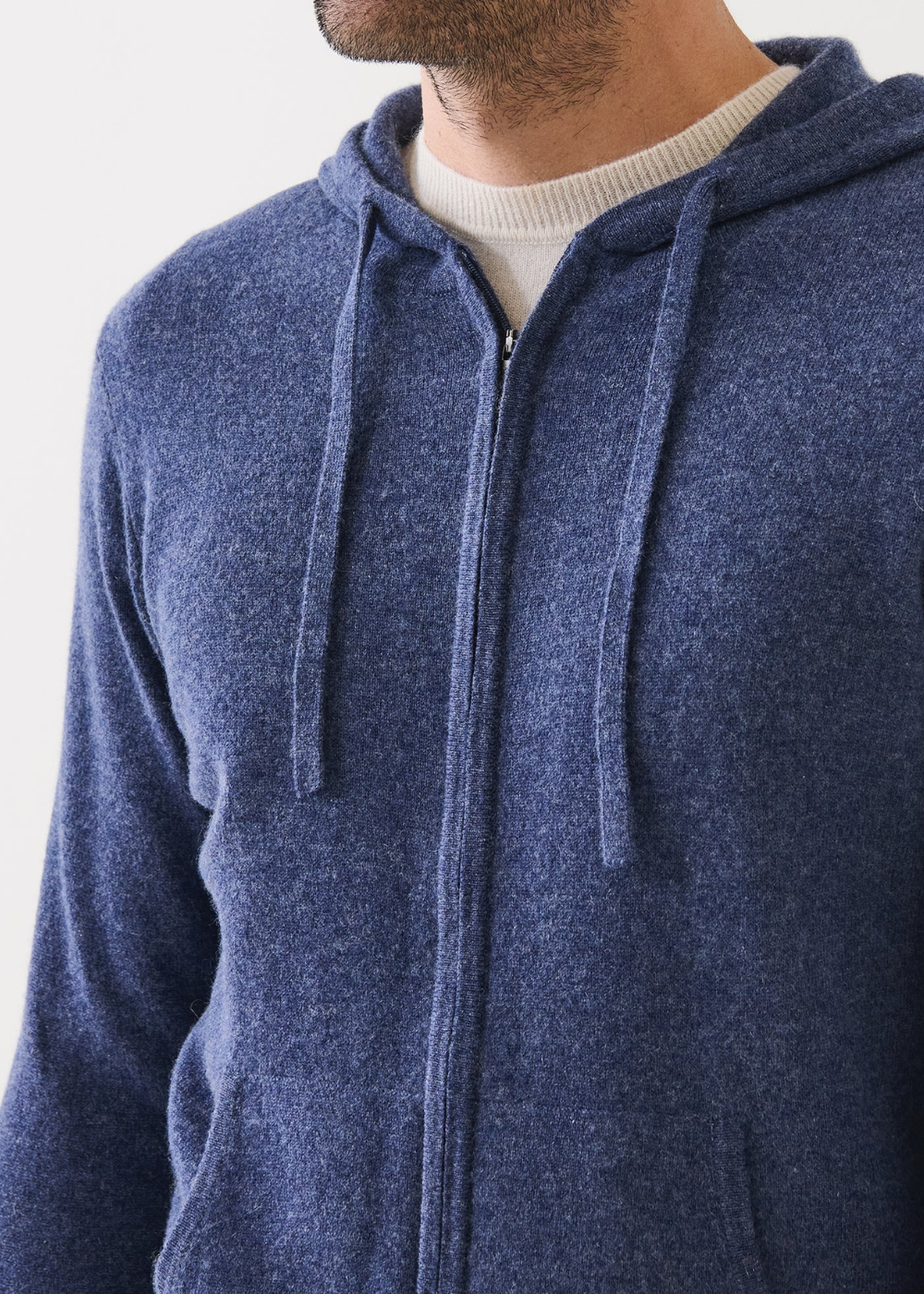 Blue hoodie worn by a person on a white background