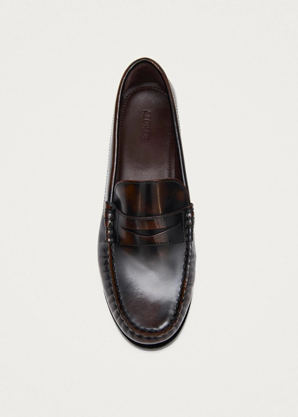 A single dark brown leather penny loafer shown from a top-down view on a light gray background.