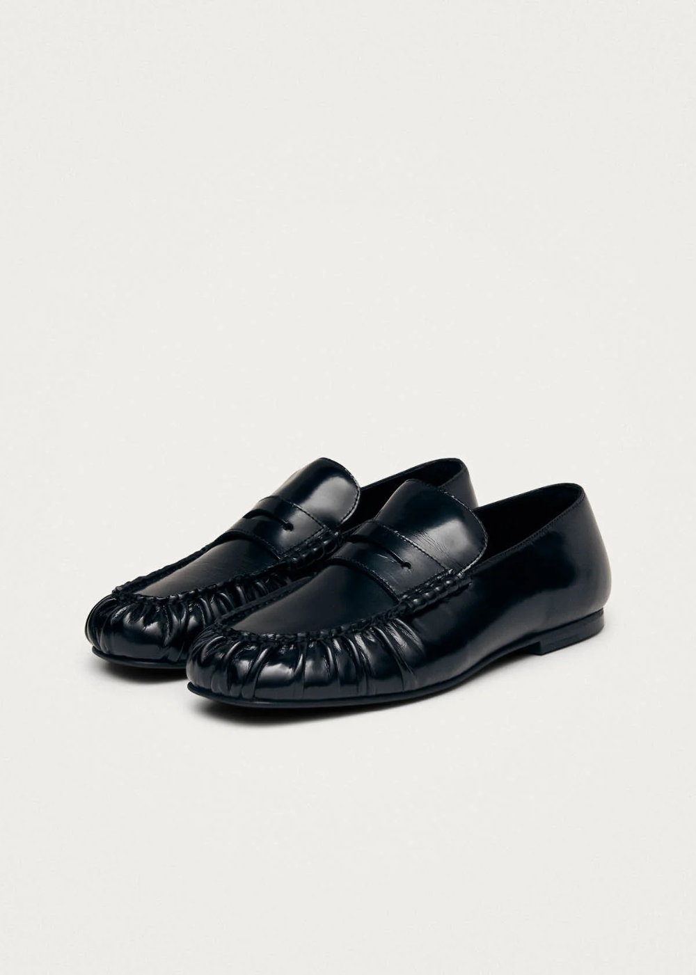 Pair of black loafers on a light gray background