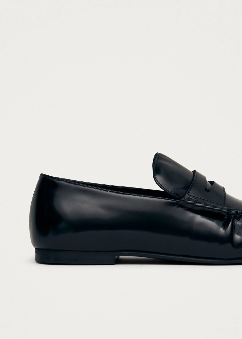 Black loafer shoe on a light gray background