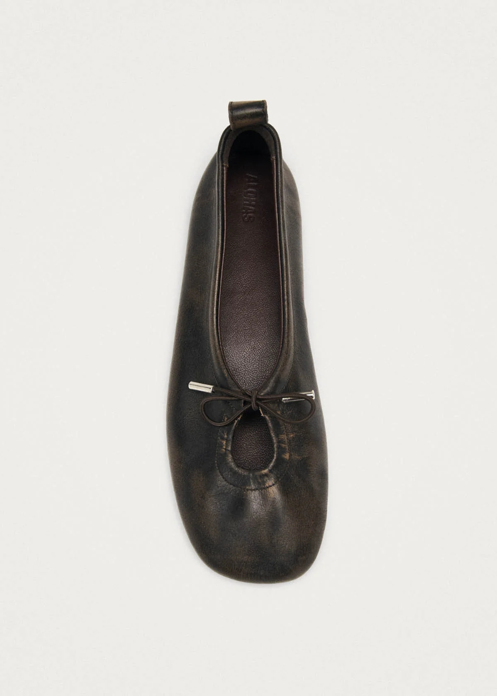 Dark brown leather ballet flat shoe on a white background