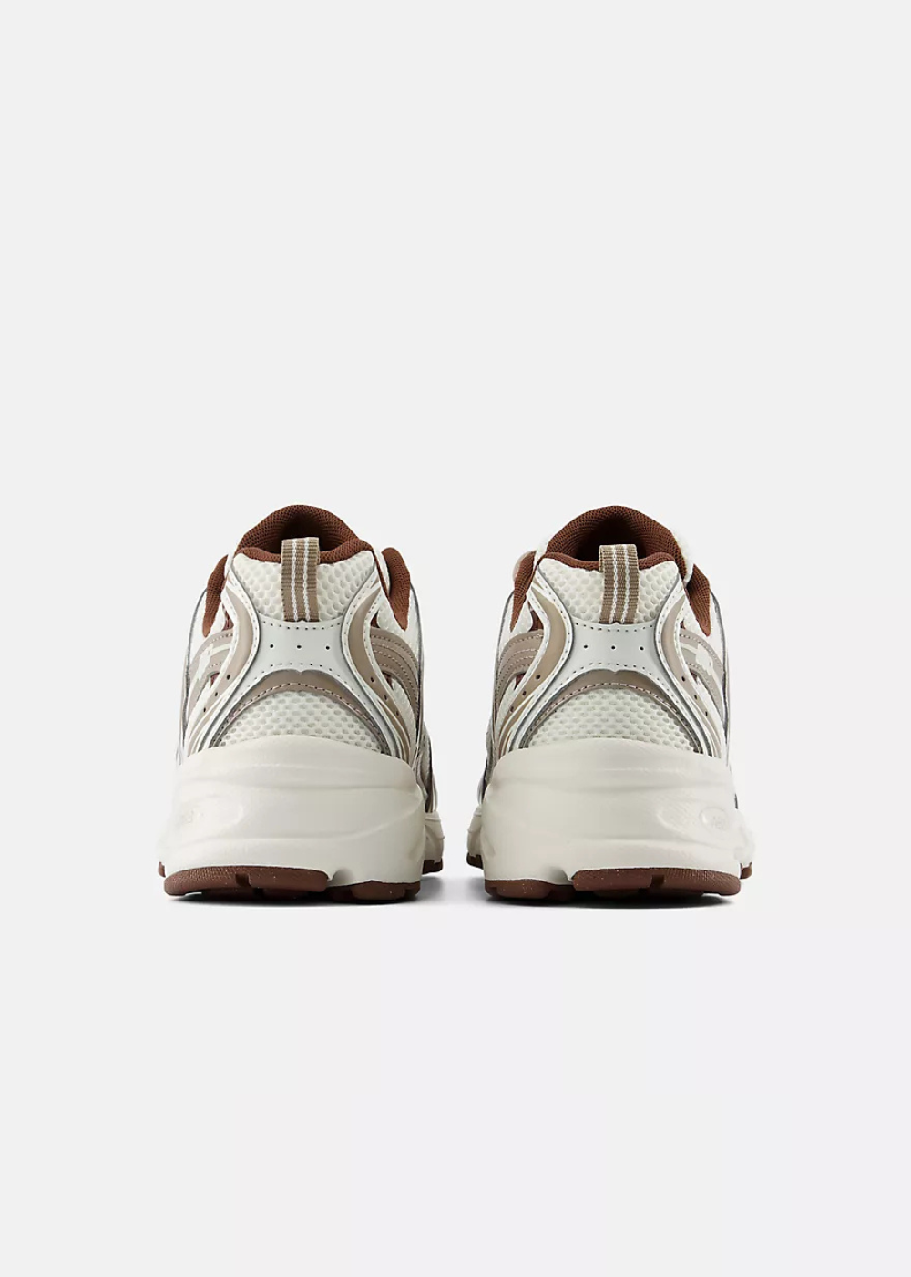 A pair of chunky platform sneakers shown from the back, featuring cream and beige mesh and synthetic panels with brown accents on the collar, lining, and outsole.