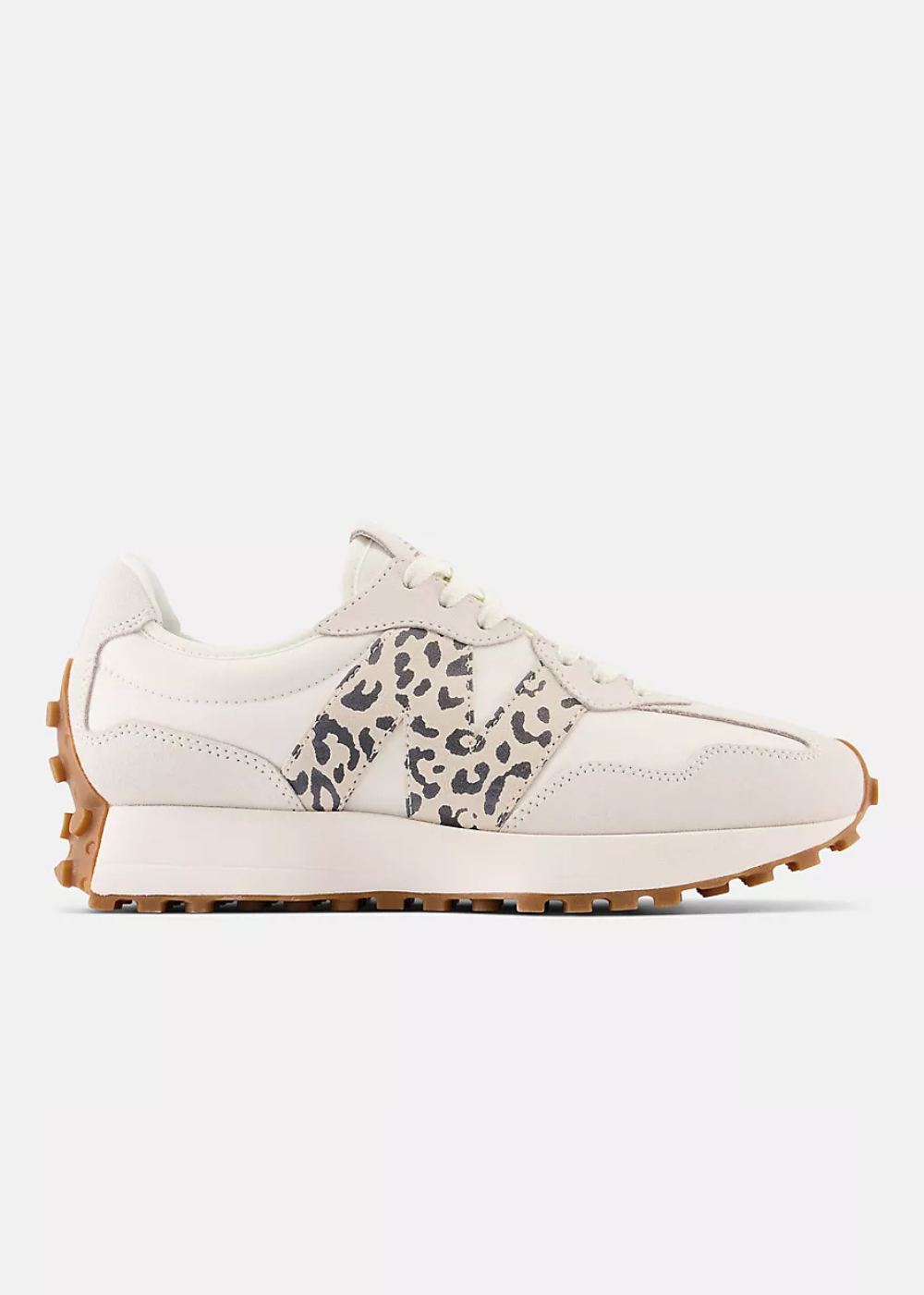 A low-top New Balance sneaker in off-white leather with a black leopard print side panel, featuring a chunky gum-brown sole.