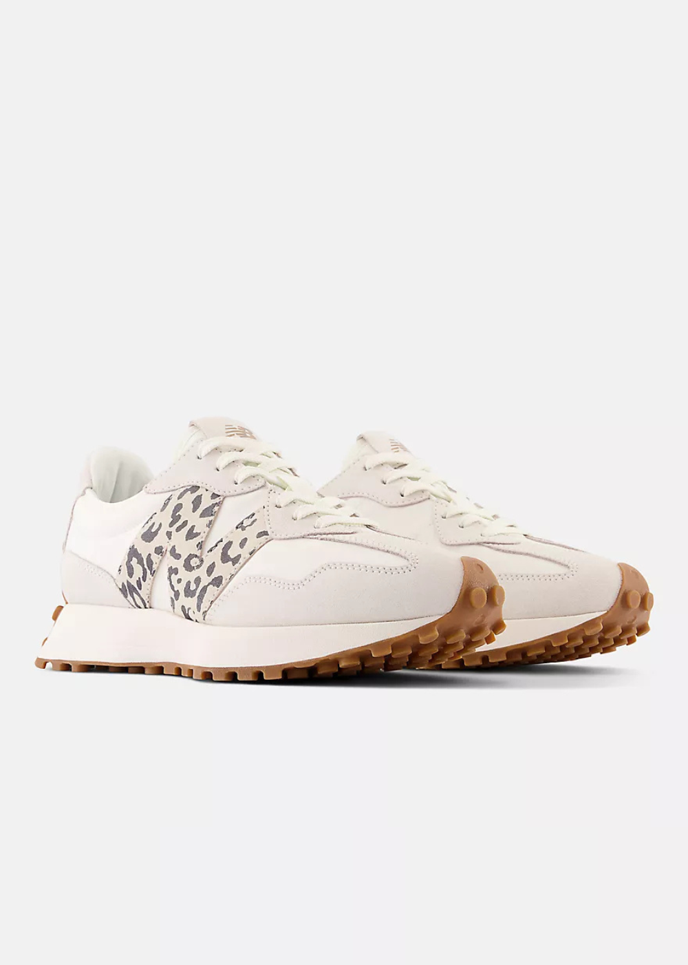 A pair of low-top sneakers in off-white and beige, featuring a leopard-print pattern on the side panels and a brown gum sole, shown against a light gray background.