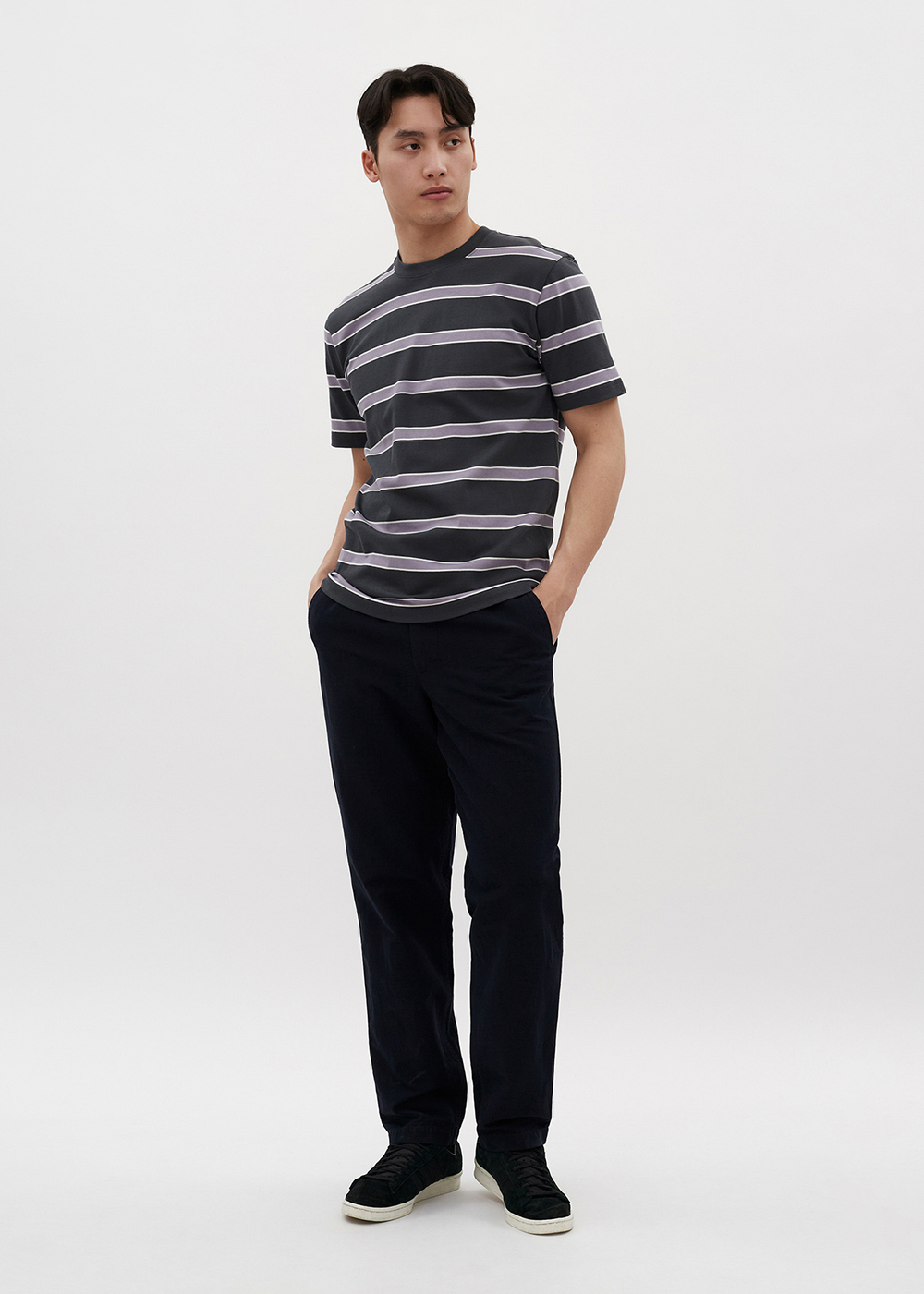 Angled view of a model wearing the Johannes Organic Multicolor Striped T-Shirt by Norse Projects in Battleship Grey.