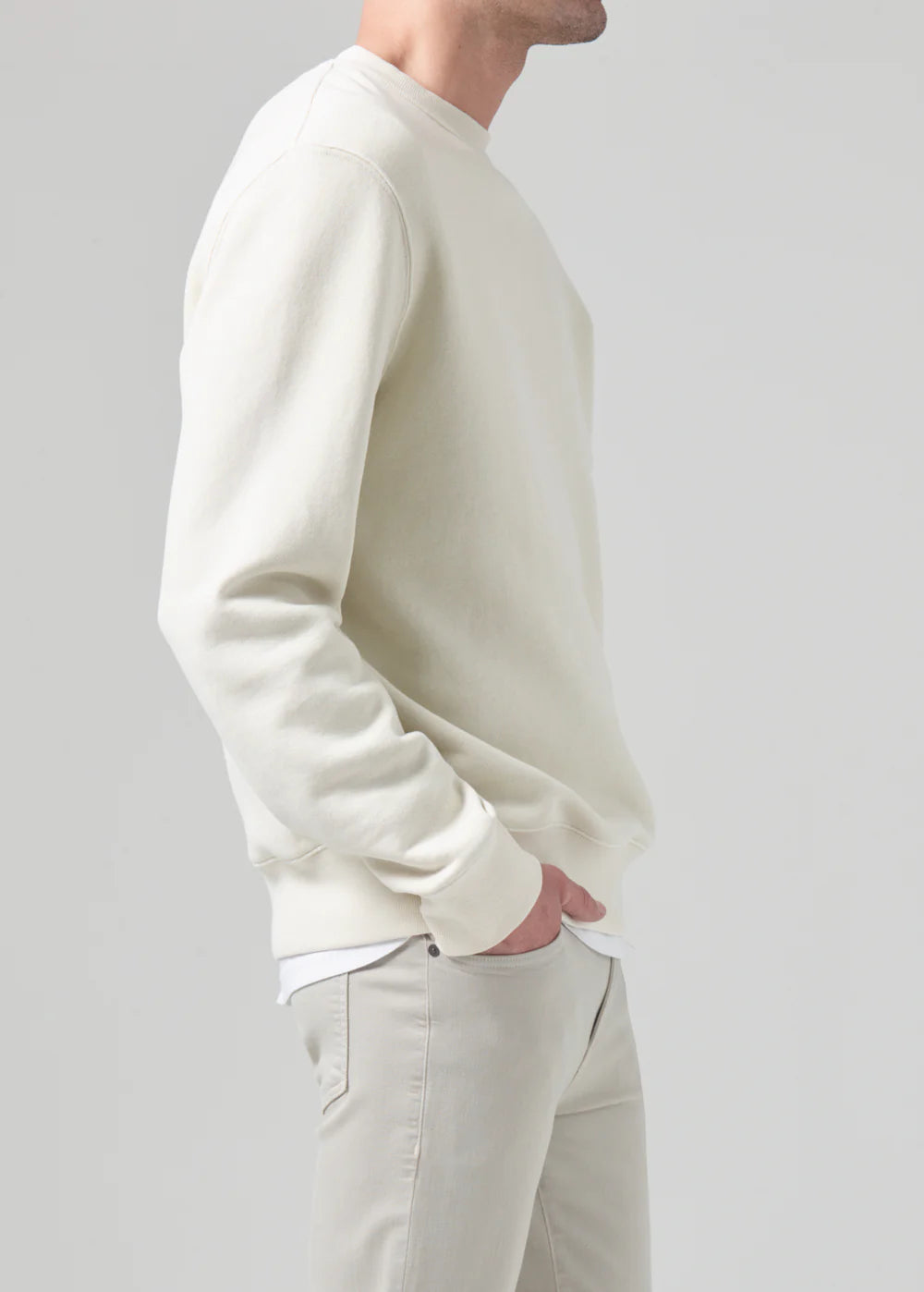 Side view of a model wearing the Vintage crewneck sweater from Citizens of Humanity in off-white cream color. Showcases the regular, comfy fit.
