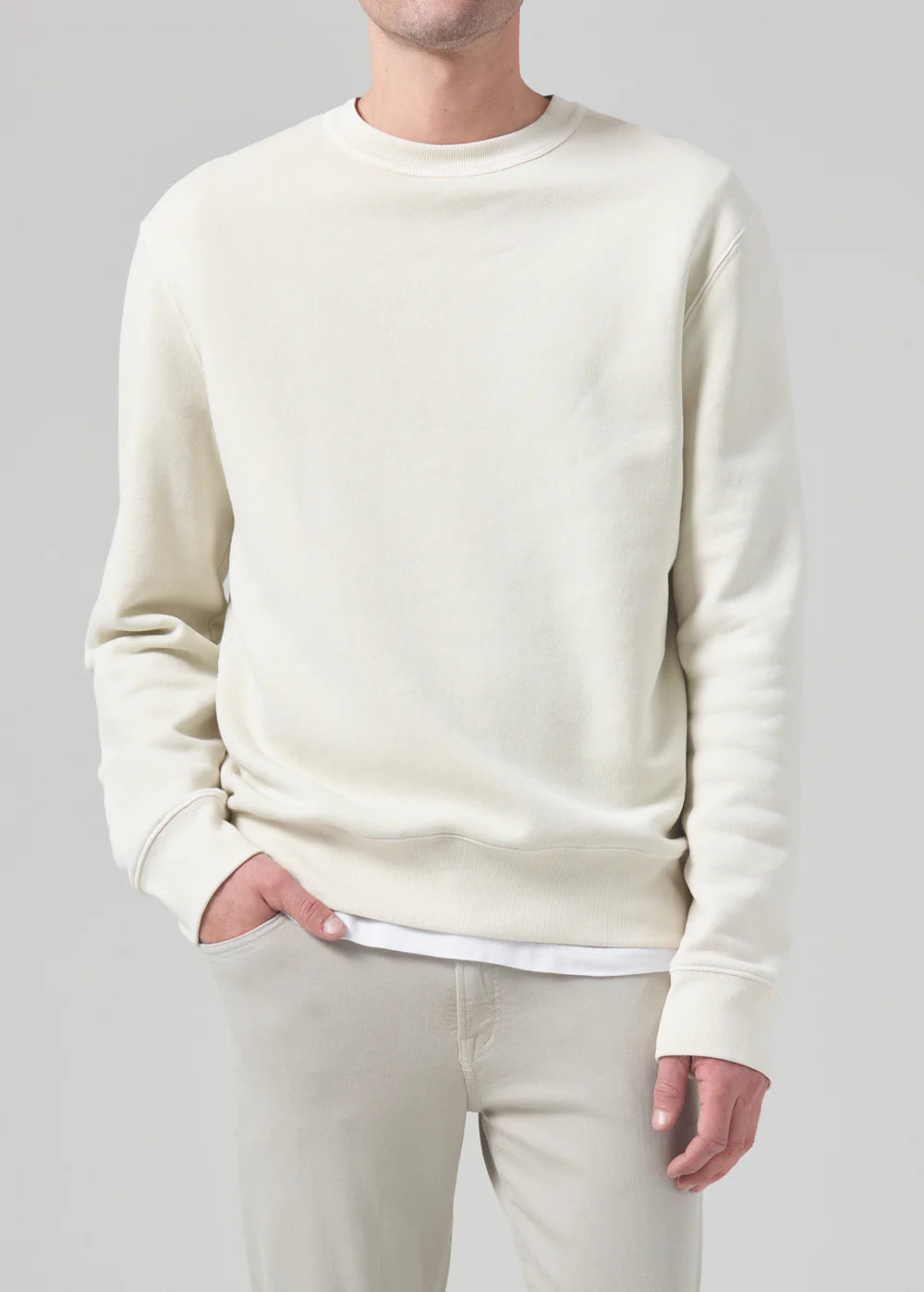 Front view of a model wearing the Vintage crewneck sweater from Citizens of Humanity in off-white cream color. Showcases the regular, comfy fit.