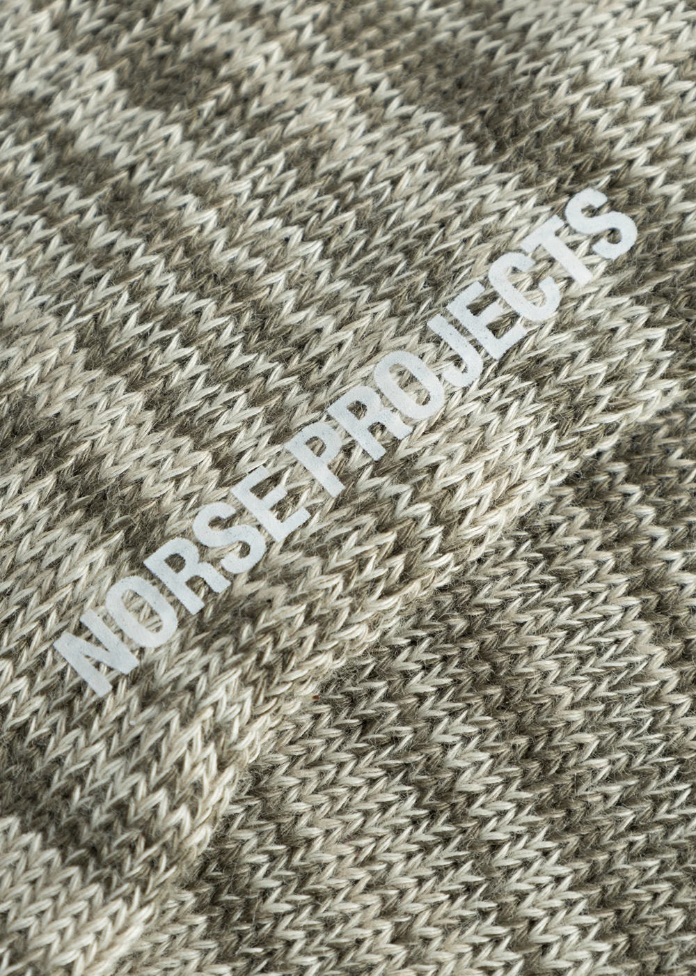 Close up view of the Bjarki Cotton Twist Sock in Sediment Green by Norse Projects, showcasing the detailed stitching in the sock. 