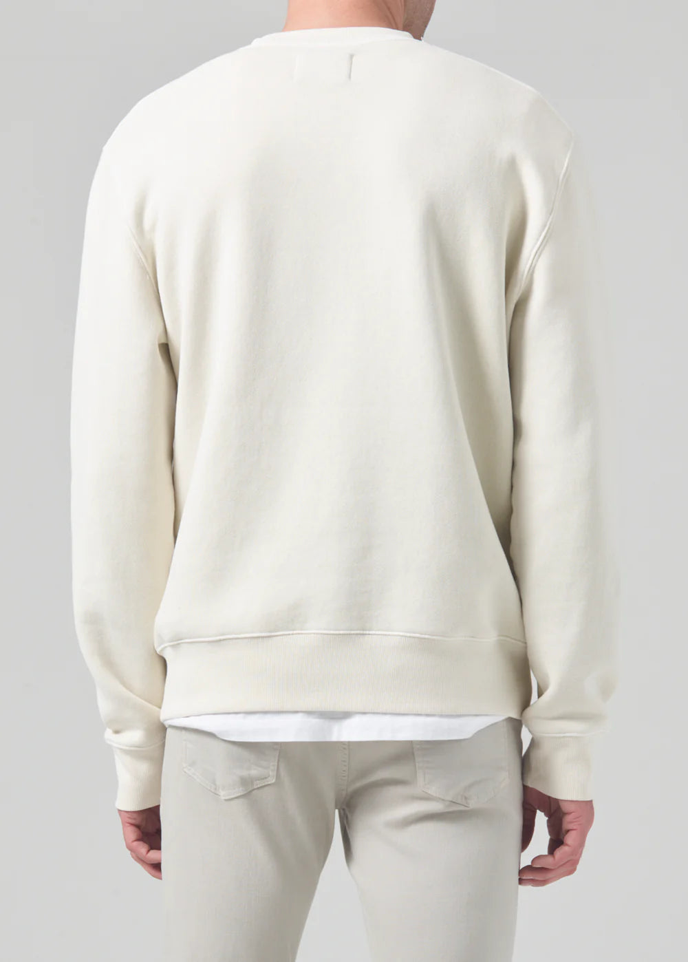 Backside view of a model wearing the Vintage crewneck sweater from Citizens of Humanity in off-white cream color. Showcases the regular, comfy fit.