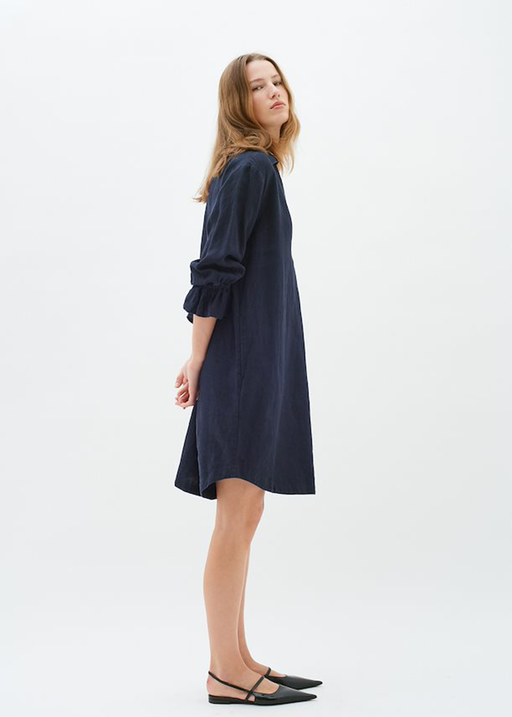Side profile of model wearing the Peg Linene Dress by InWear, showcasing the loose fit and elbow length sleeves.