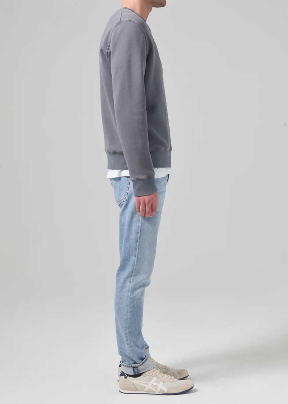 Side profile of model wearing the London from Citizens of Humanity in bright light indigo. Showcasing the slim fit jean that fits fuller in the thighs and tapers to the ankle.