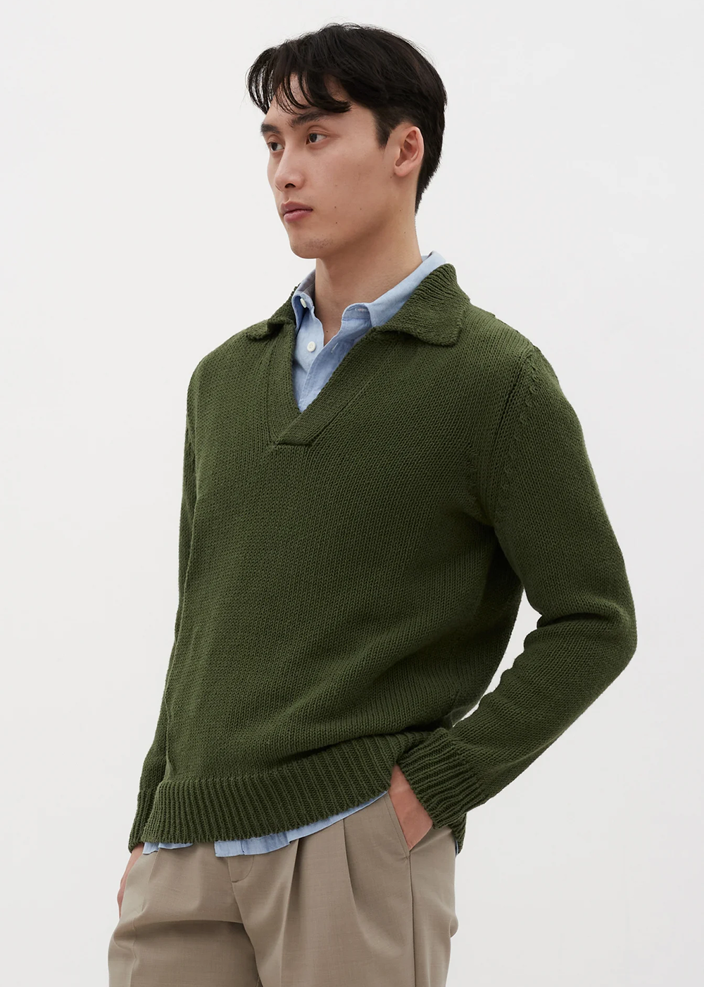 Angled side view of model wearing the Lasse Cotton Holiday Polo in Ivy Green by Norse Projects.